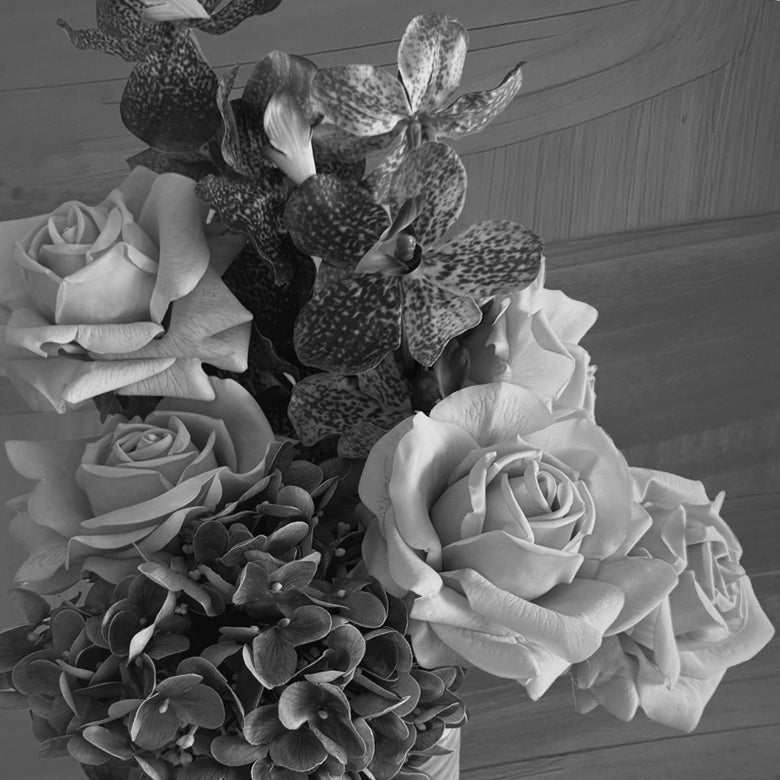 Black and white table vase arrangement with artificial roses and protea